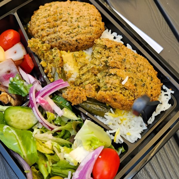 Fabi's Grill Mediterranean takeout box with falafel, rice, and a fresh salad.
